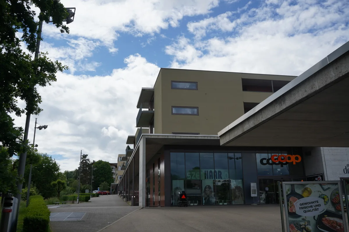 Ein Platz mit viel Beton. Dahinter ein Einkaufszentrum.